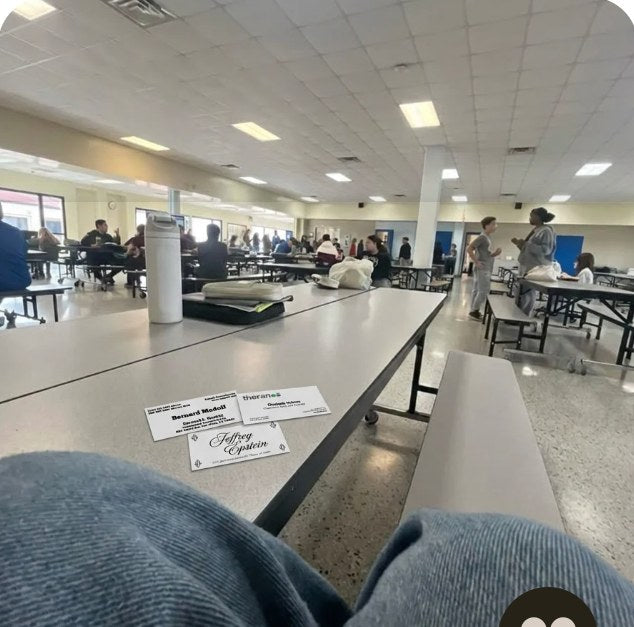 A card resting on a knee in a cafeteria